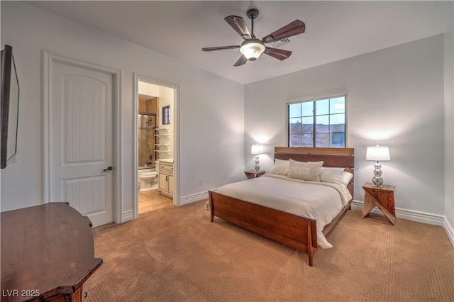 bedroom featuring light carpet, ensuite bathroom, a ceiling fan, and baseboards