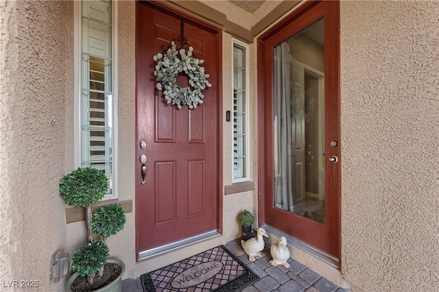 view of exterior entry with stucco siding