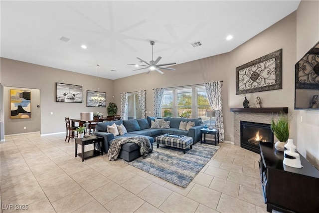 living room with light tile patterned floors, recessed lighting, visible vents, baseboards, and a glass covered fireplace