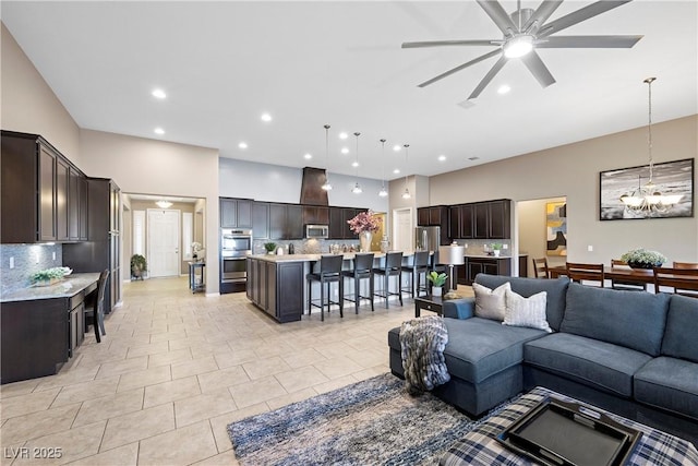 living room with light tile patterned floors, recessed lighting, and ceiling fan with notable chandelier