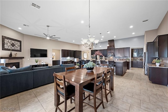 dining room with light tile patterned floors, ceiling fan with notable chandelier, visible vents, and recessed lighting