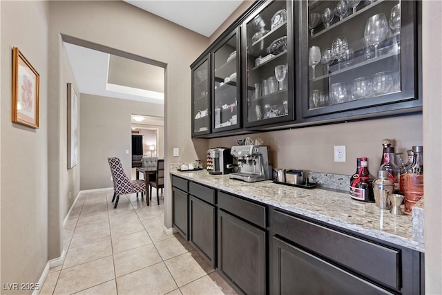 bar featuring baseboards and light tile patterned floors