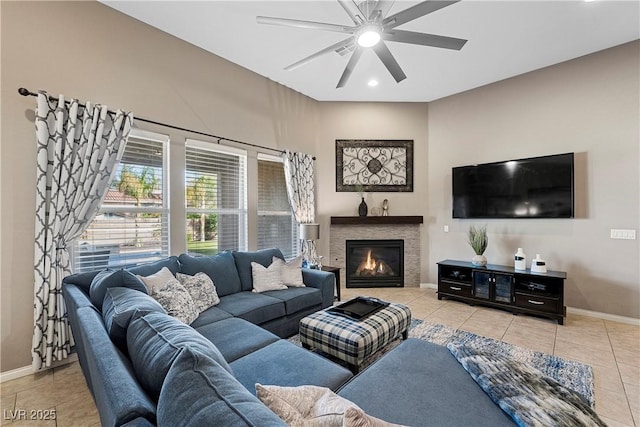 living room with light tile patterned floors, baseboards, a glass covered fireplace, ceiling fan, and recessed lighting