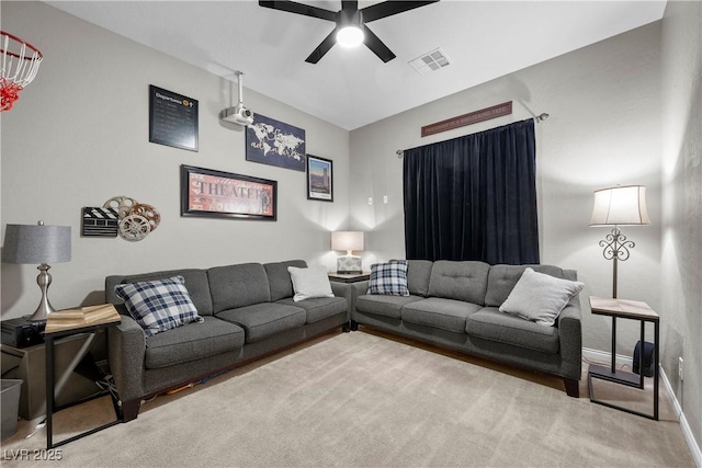 carpeted living room featuring baseboards, visible vents, and a ceiling fan