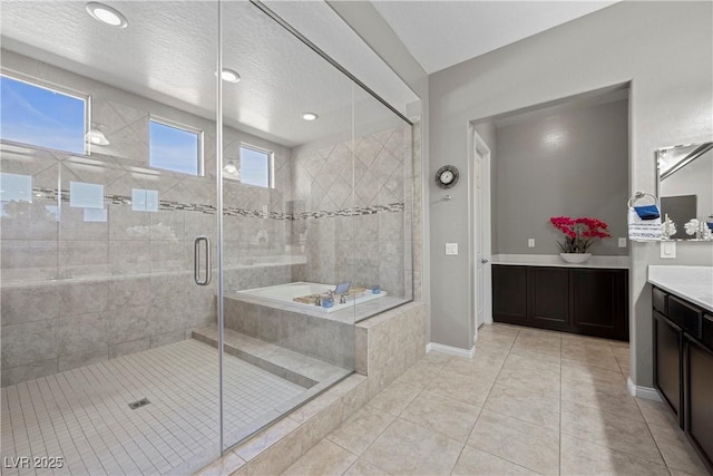 full bath with baseboards, tile patterned floors, vanity, a shower stall, and a bath