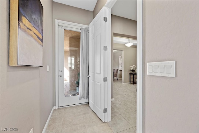 interior space with light tile patterned floors and baseboards