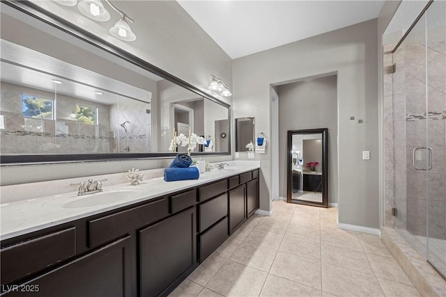 bathroom featuring double vanity, a stall shower, tile patterned flooring, and a sink