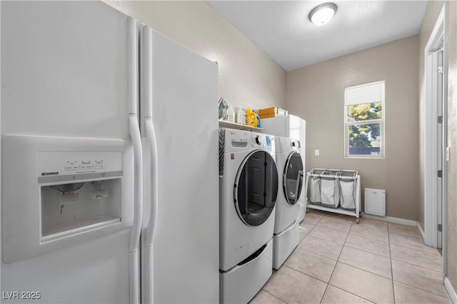 laundry area with laundry area, light tile patterned flooring, and washing machine and dryer