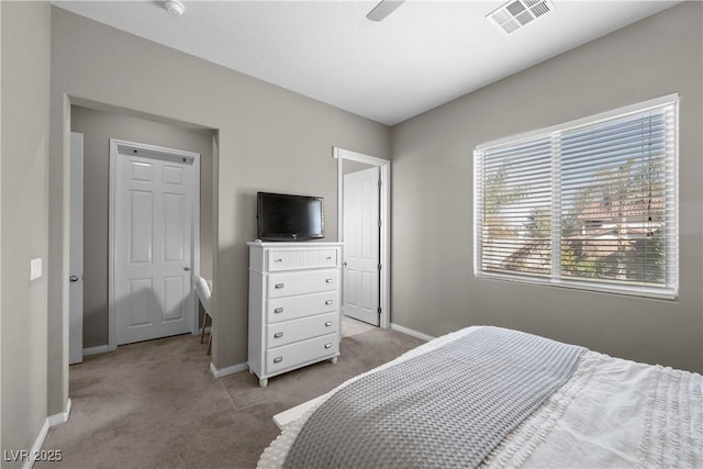 bedroom with baseboards, visible vents, and light colored carpet