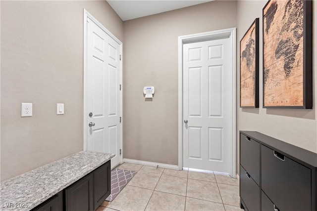 interior space with light tile patterned floors and baseboards