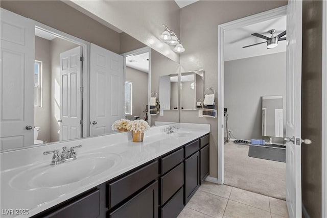 full bath with ceiling fan, toilet, a sink, tile patterned floors, and double vanity