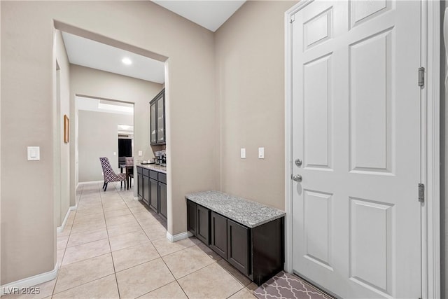 interior space with baseboards and light tile patterned floors