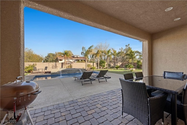 view of patio / terrace with outdoor dining space, a fenced backyard, a fenced in pool, and area for grilling