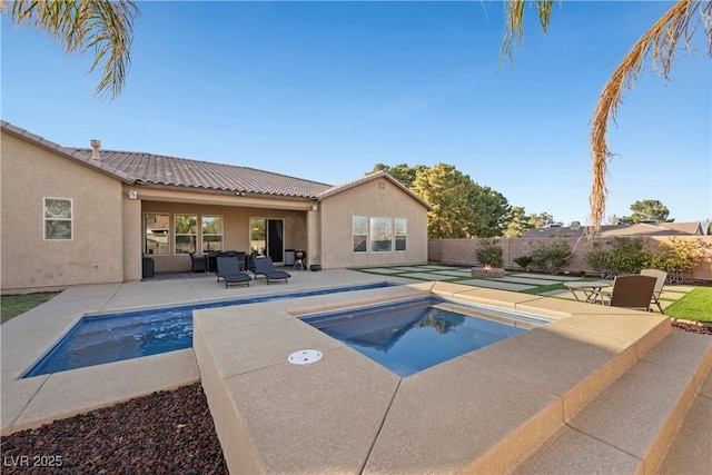 view of swimming pool featuring a jacuzzi, fence, a fenced in pool, and a patio