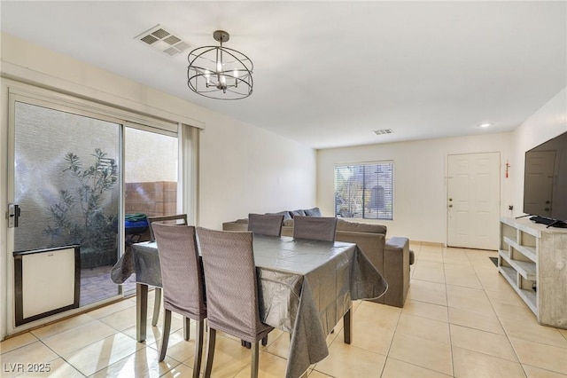 dining area featuring light tile patterned floors, visible vents, and a chandelier