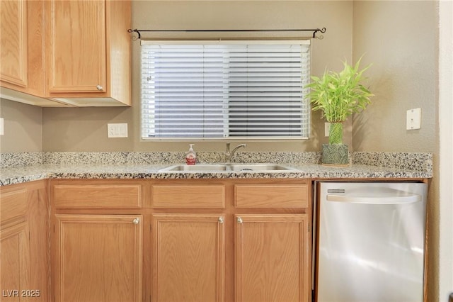 kitchen with dishwasher, light brown cabinetry, and a sink