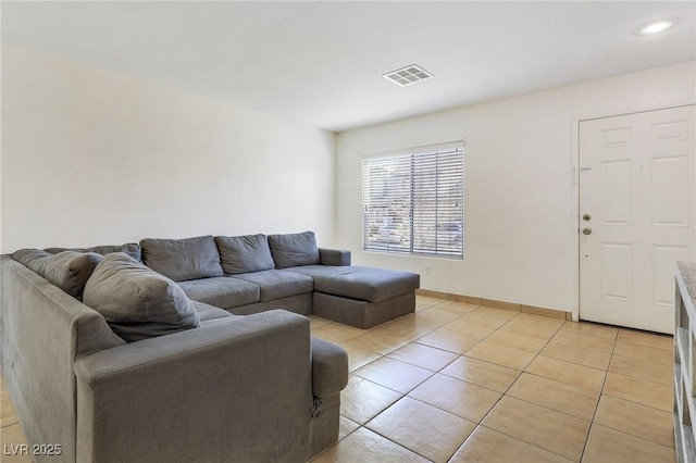 living room featuring light tile patterned floors, baseboards, and visible vents