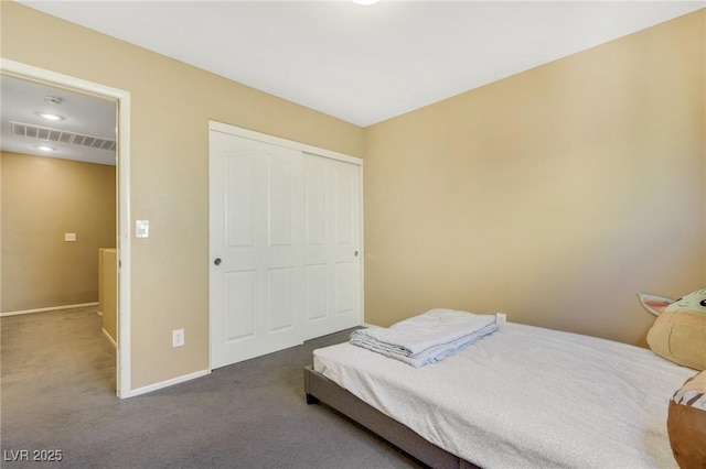 carpeted bedroom with a closet, visible vents, and baseboards