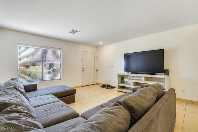 living room with light tile patterned floors, visible vents, and baseboards