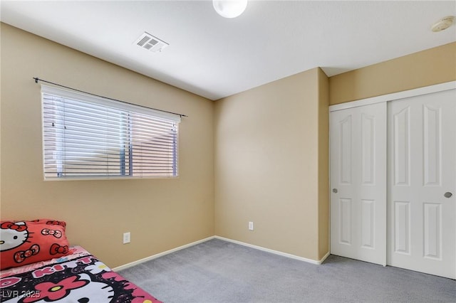 unfurnished bedroom featuring light carpet, a closet, visible vents, and baseboards