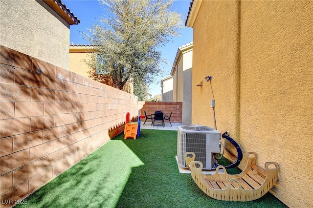 view of yard featuring a fenced backyard, central AC unit, and a patio