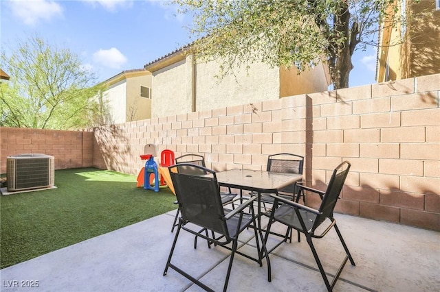 view of patio featuring cooling unit, outdoor dining area, and a fenced backyard