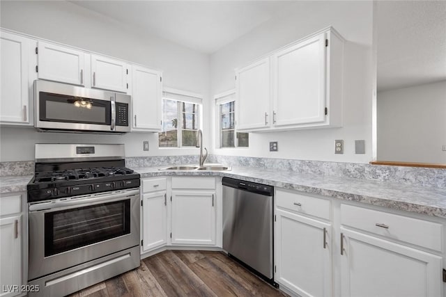 kitchen with white cabinetry, a sink, stainless steel appliances, and dark wood-type flooring
