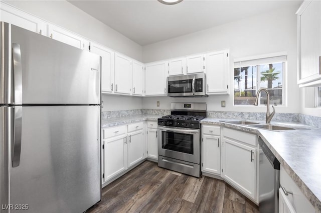 kitchen featuring light countertops, appliances with stainless steel finishes, a sink, and white cabinetry