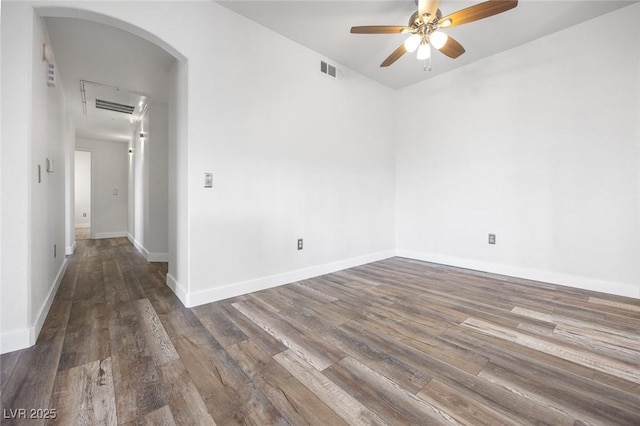 spare room with visible vents, wood finished floors, arched walkways, and ceiling fan