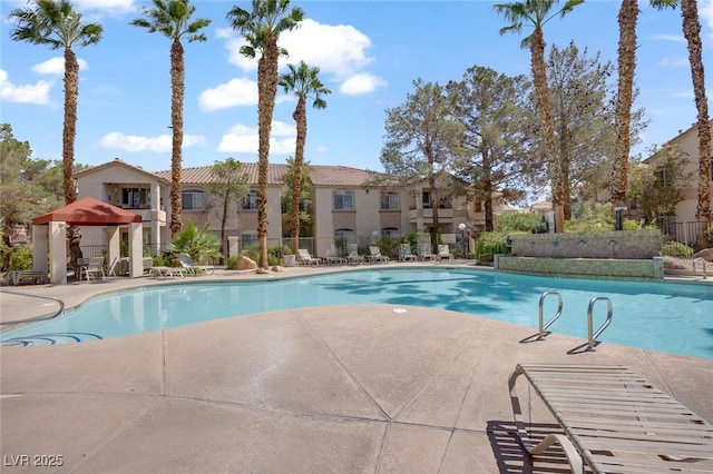 community pool with a gazebo, a patio, fence, and a residential view