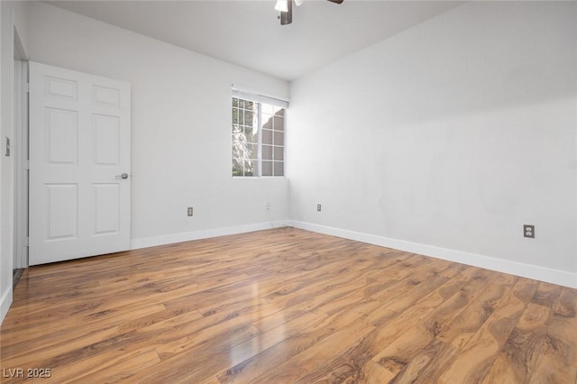 empty room with a ceiling fan, light wood-style flooring, and baseboards