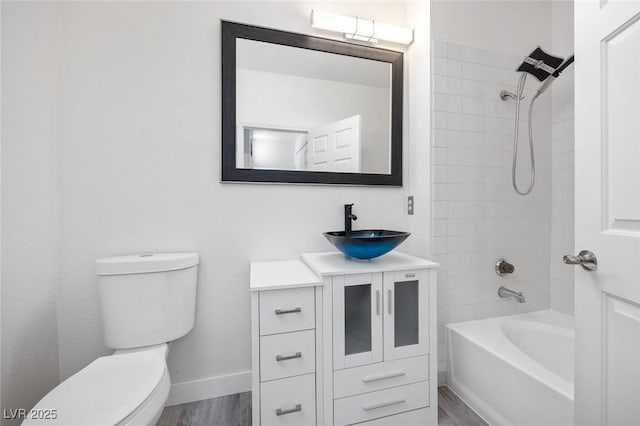 bathroom featuring shower / tub combination, baseboards, wood finished floors, and vanity