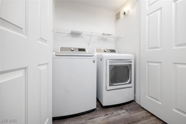 laundry area with dark wood finished floors, washer and clothes dryer, and laundry area
