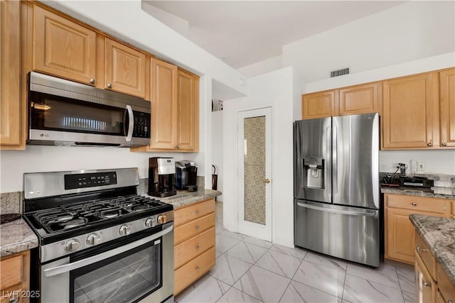 kitchen featuring marble finish floor, stainless steel appliances, light stone counters, and visible vents