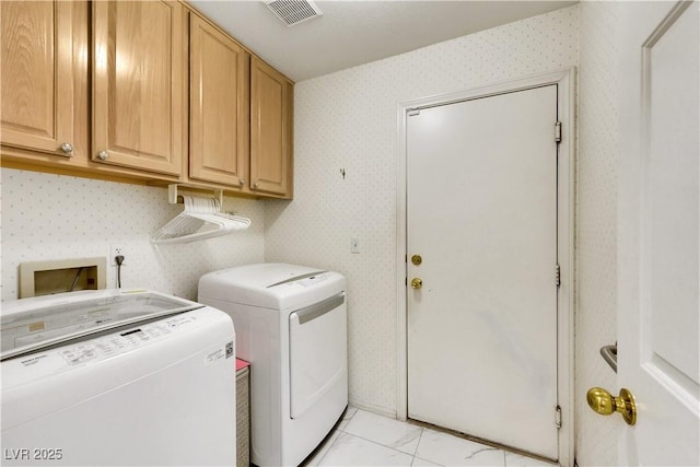 clothes washing area with cabinet space, wallpapered walls, visible vents, marble finish floor, and separate washer and dryer