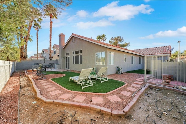 back of property featuring a fenced backyard, a lawn, a patio, and stucco siding