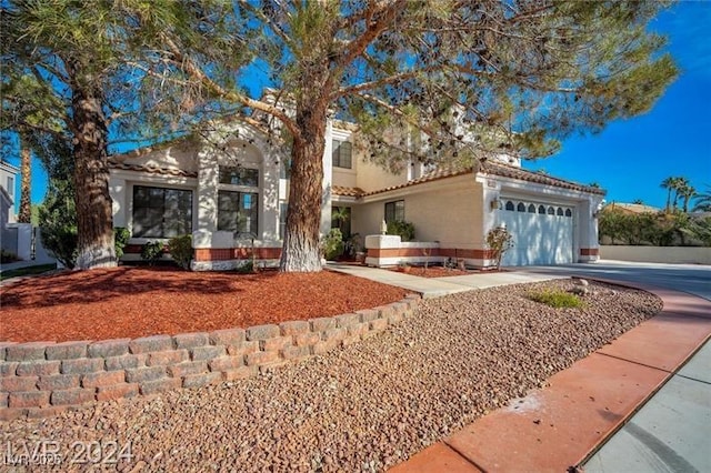 view of front of house featuring a garage, driveway, a tiled roof, and stucco siding