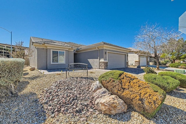 view of front of property featuring a garage, driveway, stone siding, a tiled roof, and stucco siding