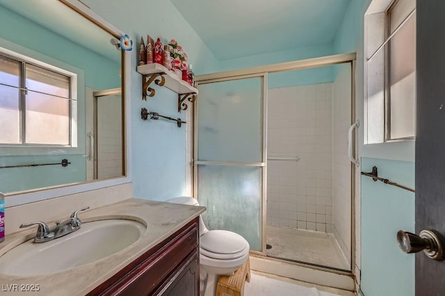 bathroom featuring a stall shower, vanity, and toilet