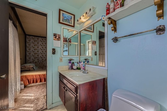 bathroom featuring a textured ceiling, vanity, toilet, and ensuite bathroom