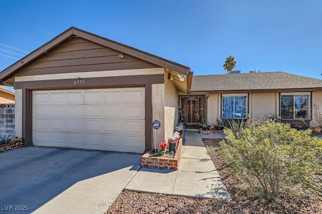 ranch-style home featuring concrete driveway, roof with shingles, an attached garage, and stucco siding