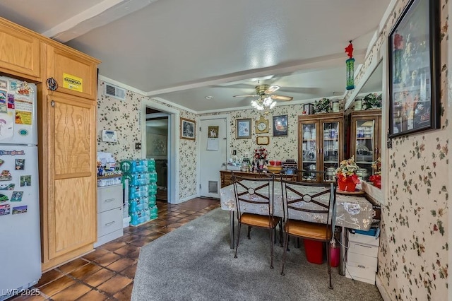 dining area featuring visible vents, ceiling fan, dark tile patterned floors, and wallpapered walls