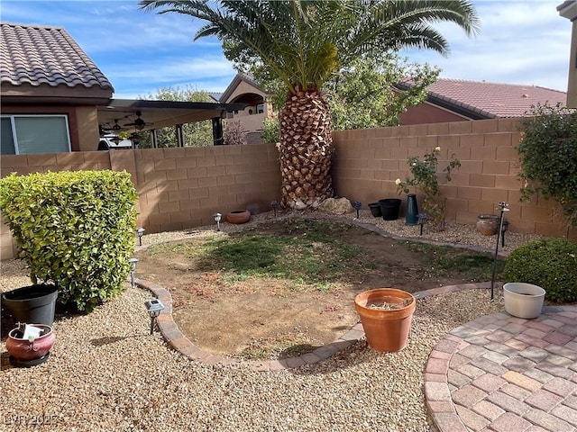 view of yard with a patio area, a fenced backyard, and a ceiling fan