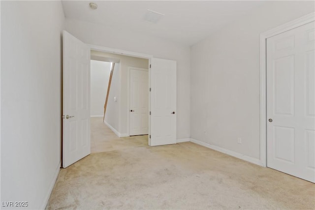 unfurnished bedroom featuring light carpet and baseboards