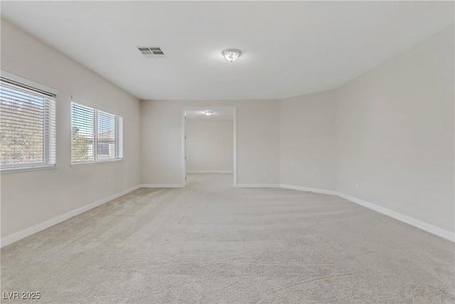 unfurnished room featuring light colored carpet, visible vents, and baseboards