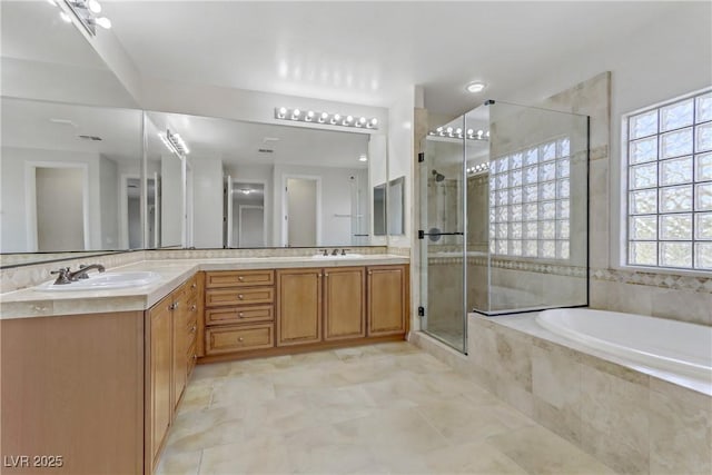 bathroom with a garden tub, a sink, a shower stall, and double vanity