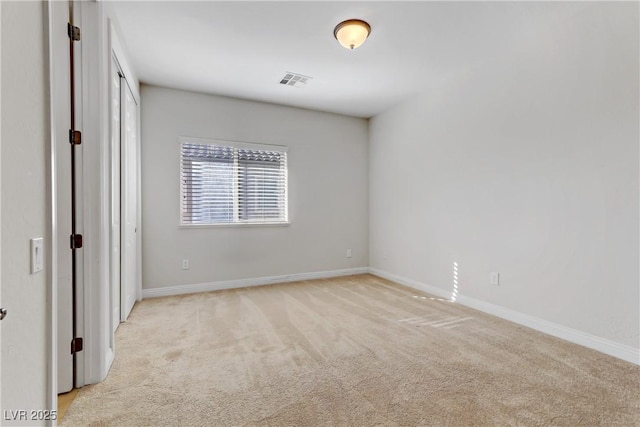 unfurnished room featuring light colored carpet, visible vents, and baseboards