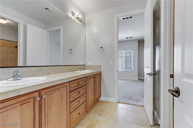 bathroom featuring double vanity, visible vents, a sink, and tile patterned floors