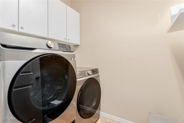 washroom featuring washer and dryer, cabinet space, baseboards, and light tile patterned floors