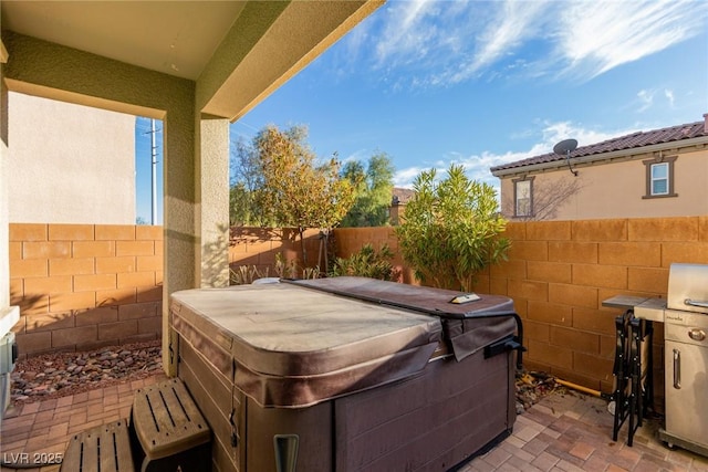 view of patio / terrace with a hot tub and a fenced backyard